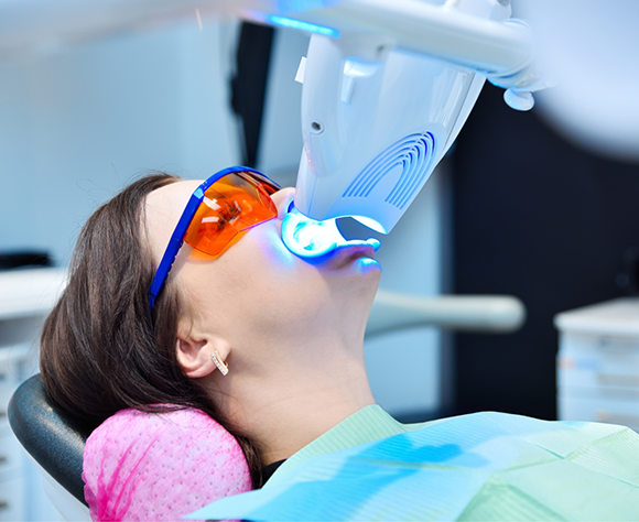 Female dental patient having teeth whitened with Zoom! system