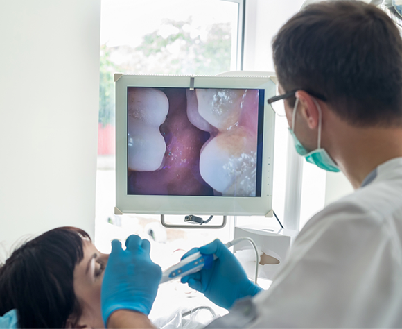 Dentist examining patients teeth with intraoral camera