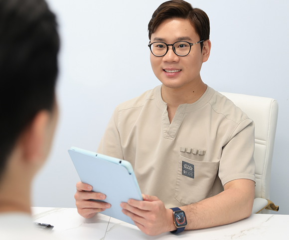 Fort Lee dentist holding tablet and talking to patient