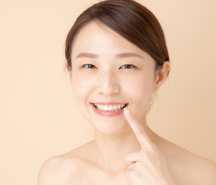 Woman smiling and pointing to her teeth