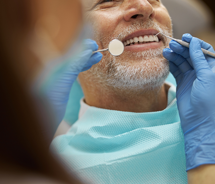 Man in dental chair having teeth examined by dentist for preventive dentistry