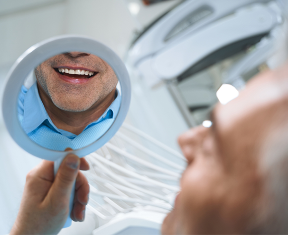 Man checking smile in mirror