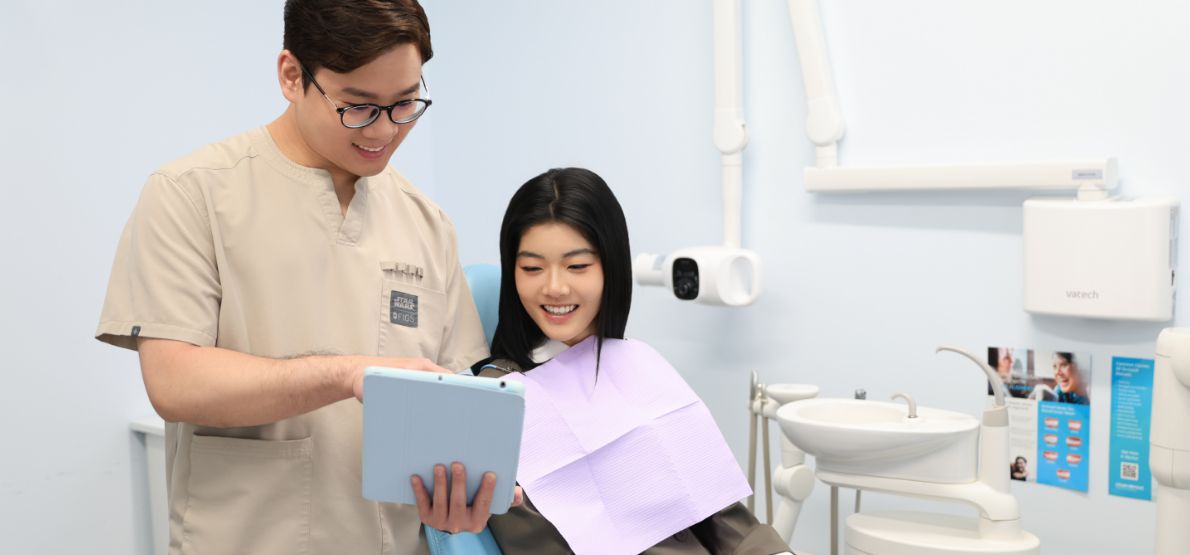 Dental team member showing female patient a clipboard