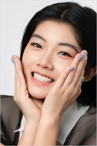 Woman smiling and holding hands in cheeks