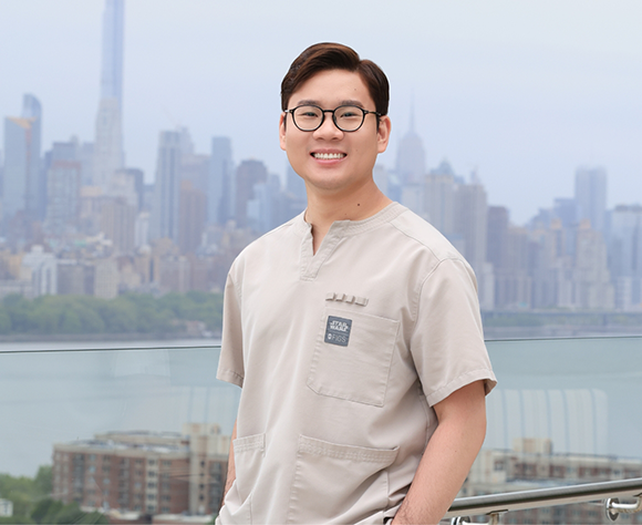 Dr. Chang smiling in front of view of city