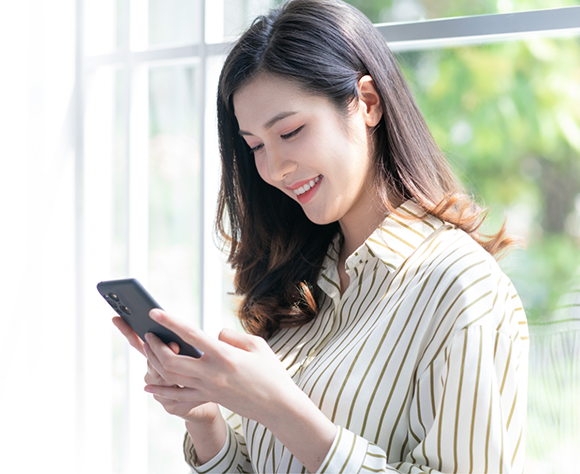 Woman in striped shirt looking at phone